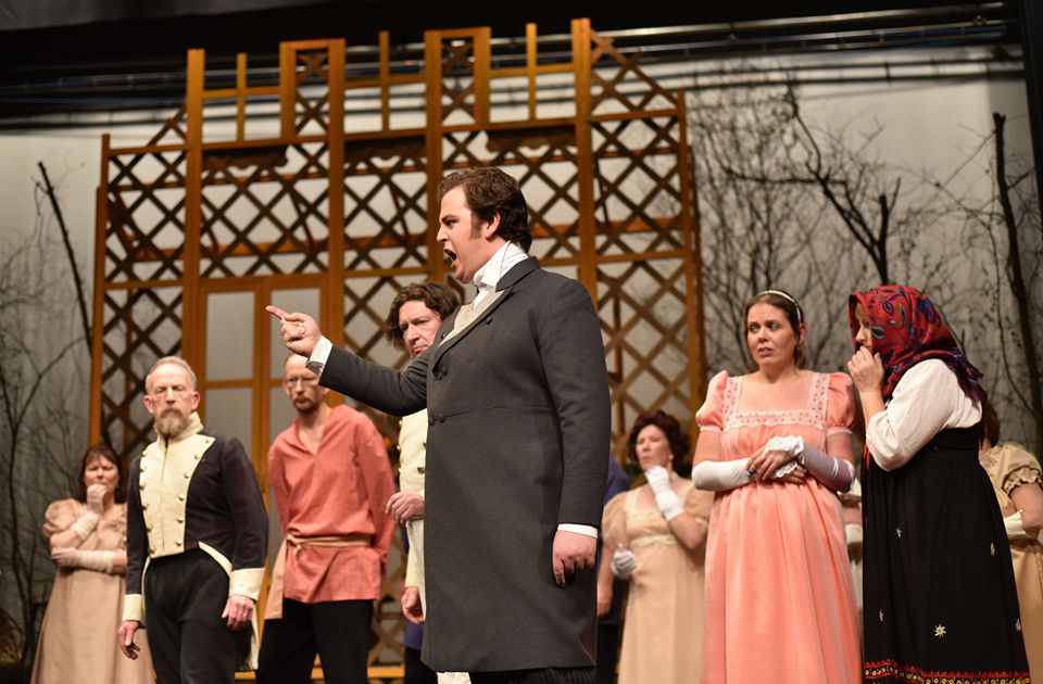 Colour photograph of Jonathan Forbes Kennedy, baritone, on stage singing the title role in a production of Tchaikovsky's Eugene Onegin by Fife Opera (photo credit: Douglas Taylor for Fife Opera)